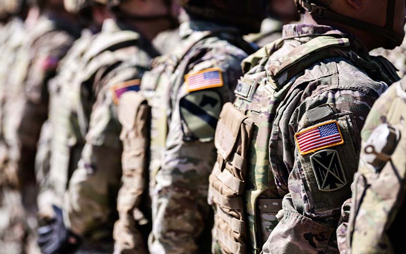 A line of American soldiers in camouflage gear standing in formation.